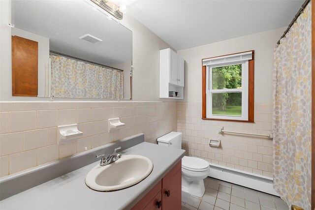29 Chestnut St, Poughkeepsie, NY 12601 - bathroom featuring a baseboard heating unit, tile patterned flooring, vanity, tile walls, and wainscoting