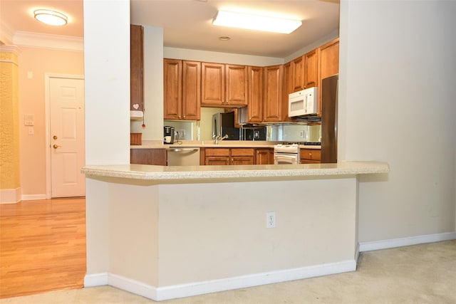 30 N De Baun Ave N Unit 208, Suffern, NY 10901 - kitchen featuring appliances with stainless steel finishes, light countertops, brown cabinets, crown molding, and a peninsula