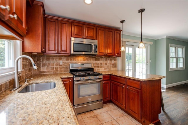 56 Lakeland Ave, Babylon, NY 11702 - kitchen with stainless steel appliances, a peninsula, backsplash, crown molding, and hanging light fixtures