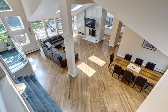 64 Highland Ave, Roslyn, NY 11576 - living room with wood finished floors, a baseboard heating unit, and a high end fireplace