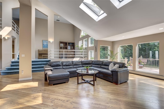 64 Highland Ave, Roslyn, NY 11576 - living area featuring high vaulted ceiling, stairs, wood finished floors, baseboard heating, and a skylight