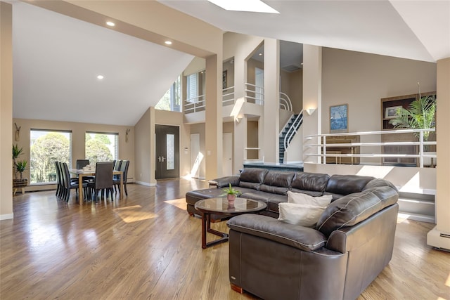 64 Highland Ave, Roslyn, NY 11576 - living area featuring high vaulted ceiling, stairs, light wood-style flooring, and recessed lighting