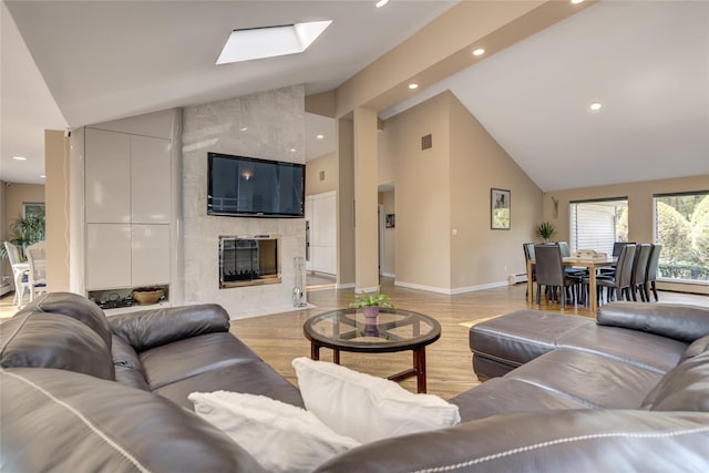 64 Highland Ave, Roslyn, NY 11576 - living area with light wood finished floors, a baseboard heating unit, high vaulted ceiling, recessed lighting, and a high end fireplace
