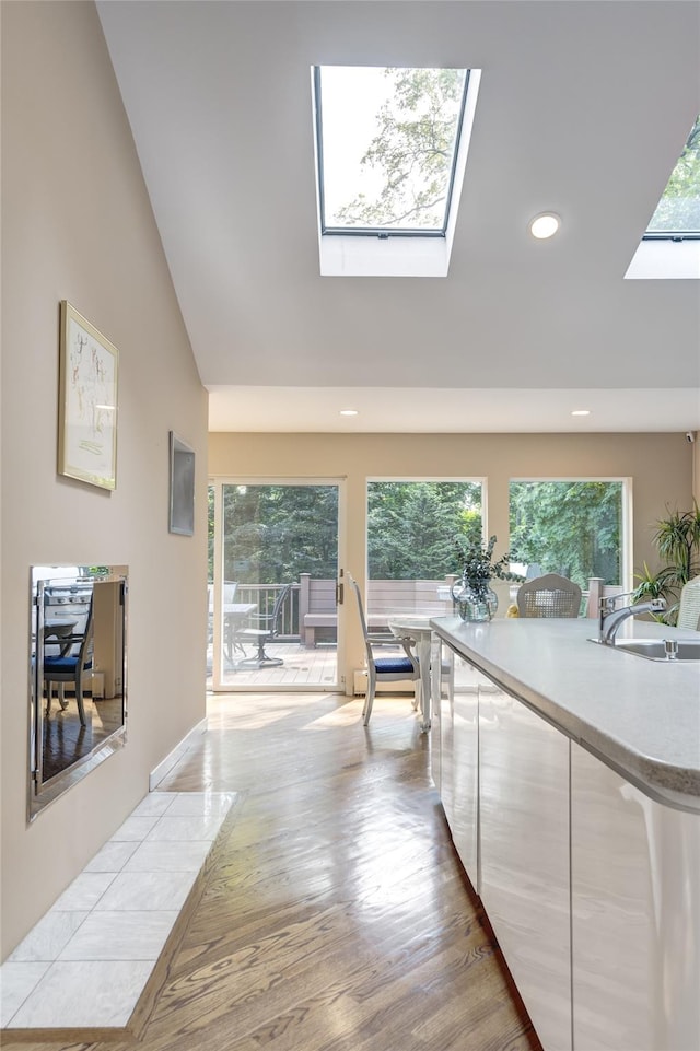 64 Highland Ave, Roslyn, NY 11576 - hall with a skylight, recessed lighting, light wood finished floors, and lofted ceiling