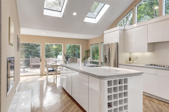 64 Highland Ave, Roslyn, NY 11576 - kitchen featuring stainless steel refrigerator with ice dispenser, white stovetop, modern cabinets, high vaulted ceiling, and recessed lighting