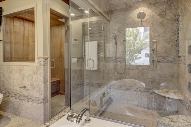 64 Highland Ave, Roslyn, NY 11576 - bathroom with tile walls, a shower stall, and wainscoting