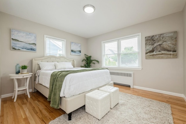 1086 Lehman Rd, West Hempstead, NY 11552 - bedroom with radiator heating unit, multiple windows, and wood finished floors