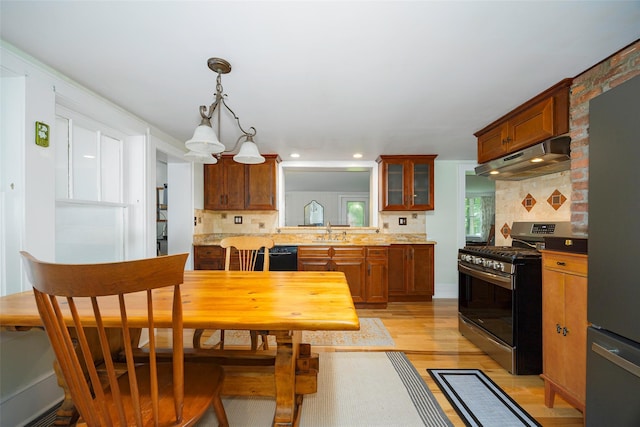 591 Hillside Lake Rd, Wappingers Falls, NY 12590 - kitchen with appliances with stainless steel finishes, under cabinet range hood, light wood-type flooring, decorative backsplash, and light countertops