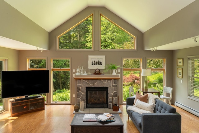 70 Reardon York Est, Canaan, NY 12029 - living area with baseboard heating, wood finished floors, high vaulted ceiling, and a stone fireplace
