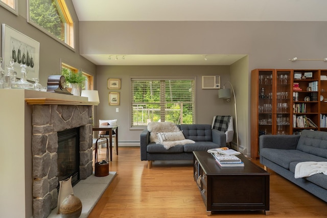 70 Reardon York Est, Canaan, NY 12029 - living room with a baseboard heating unit, light wood-style floors, an AC wall unit, and a stone fireplace