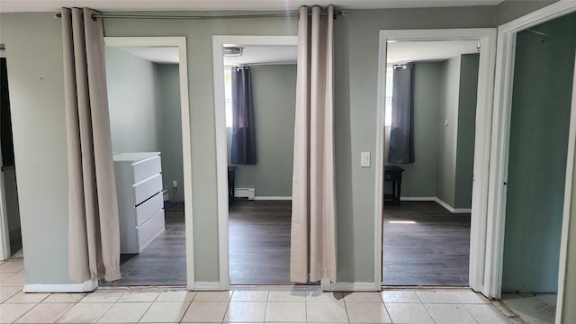 663 N Dunton Ave, East Patchogue, NY 11772 - hallway with a baseboard radiator and light tile patterned floors