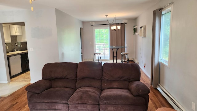 663 N Dunton Ave, East Patchogue, NY 11772 - living area with baseboard heating, light wood-type flooring, a wall mounted AC, and a chandelier