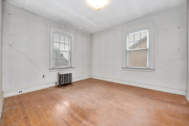 88-11 79th Ave, Glendale, NY 11385 - empty room with radiator heating unit and wood finished floors