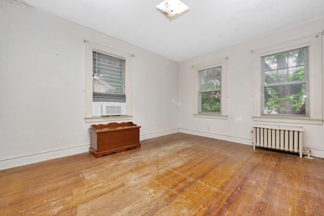 88-11 79th Ave, Glendale, NY 11385 - empty room featuring radiator, cooling unit, and wood-type flooring