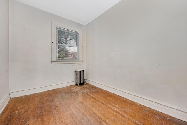 88-11 79th Ave, Glendale, NY 11385 - spare room featuring radiator heating unit and wood finished floors