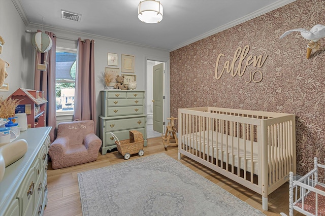 135 Vanderbilt Blvd, Oakdale, NY 11769 - bedroom with light wood finished floors, ornamental molding, wallpapered walls, and a nursery area