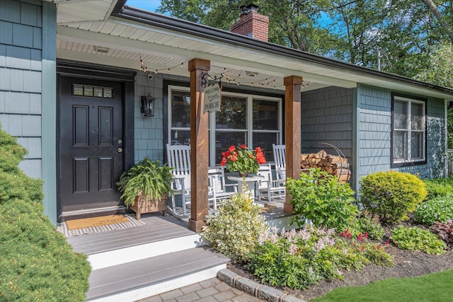 135 Vanderbilt Blvd, Oakdale, NY 11769 - doorway to property featuring covered porch and a chimney