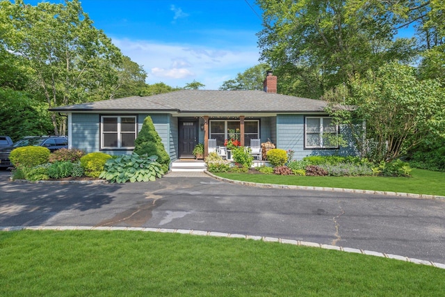 135 Vanderbilt Blvd, Oakdale, NY 11769 - ranch-style home with a porch, a chimney, a front yard, and a shingled roof