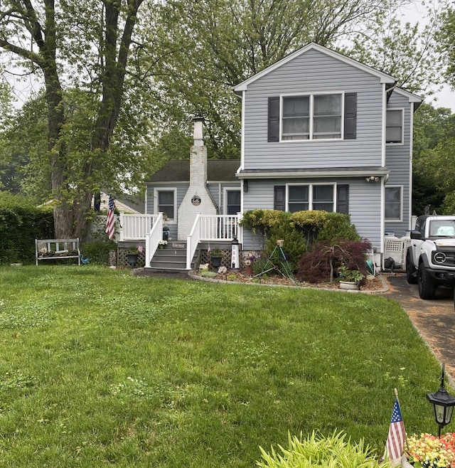 3 Liberty Pl E, Patchogue, NY 11772 - view of front of home featuring a deck, a front yard, and a chimney