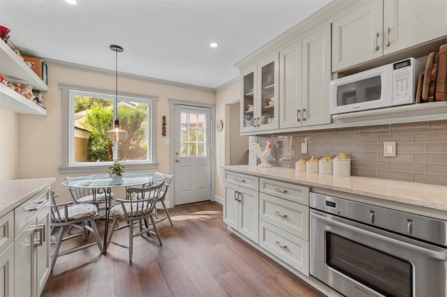19 Salisbury Dr N, East Northport, NY 11731 - kitchen with stainless steel oven, crown molding, glass insert cabinets, wood finished floors, and decorative backsplash