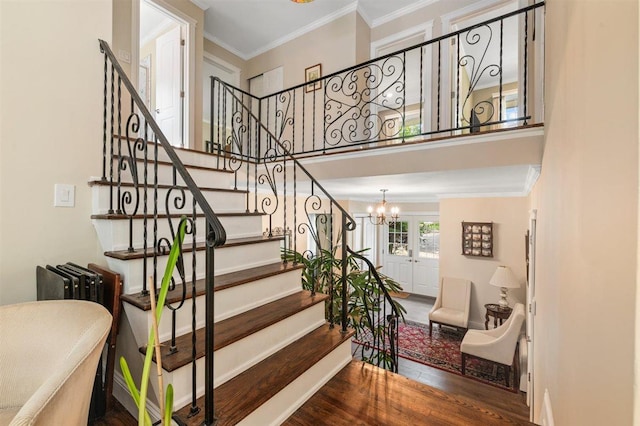19 Salisbury Dr N, East Northport, NY 11731 - stairway featuring ornamental molding, a chandelier, wood finished floors, and a high ceiling