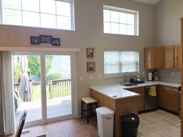 7 Shady Ln Unit 1, Central Islip, NY 11722 - kitchen featuring stainless steel dishwasher, a peninsula, a high ceiling, and light countertops