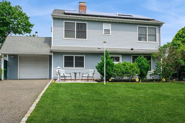 27 The Plains Rd, Levittown, NY 11756 - view of front facade with an attached garage, a front yard, driveway, and roof mounted solar panels