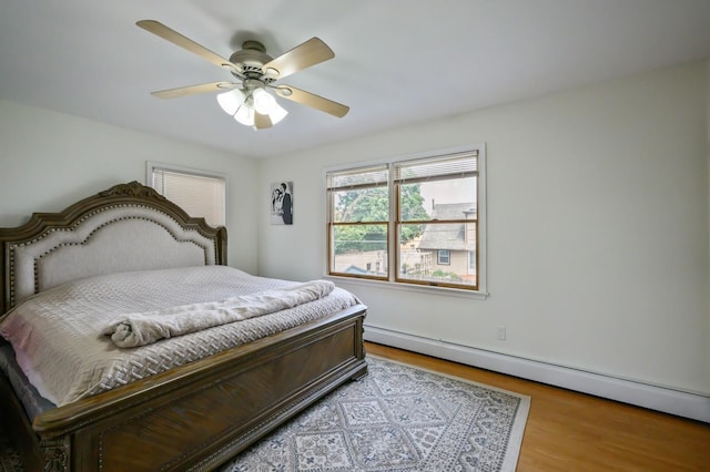 27 The Plains Rd, Levittown, NY 11756 - bedroom with a baseboard heating unit, wood finished floors, and ceiling fan