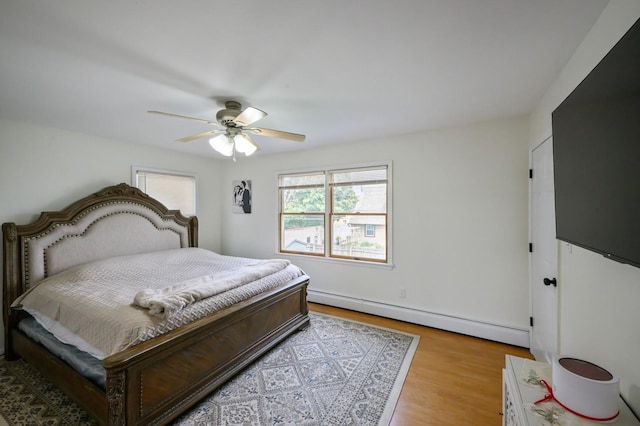 27 The Plains Rd, Levittown, NY 11756 - bedroom featuring baseboard heating, wood finished floors, and ceiling fan