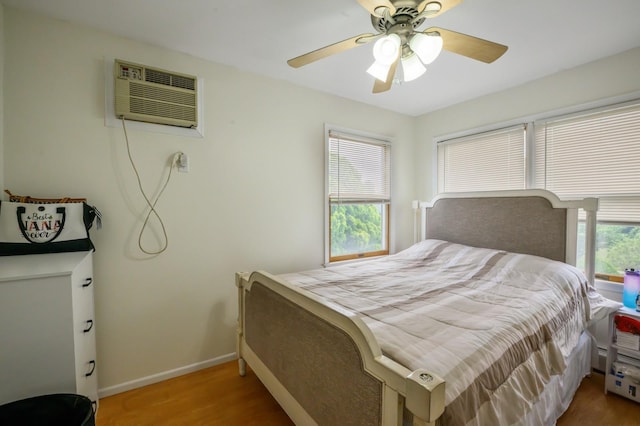 27 The Plains Rd, Levittown, NY 11756 - bedroom with a wall unit AC, wood finished floors, and ceiling fan