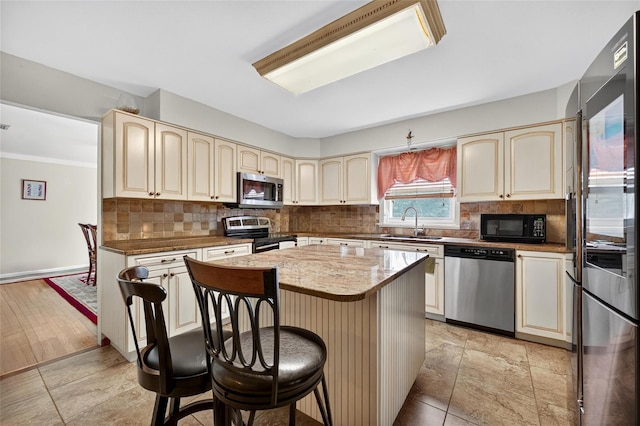 4 Debbie Ct, Chester, NY 10918 - kitchen featuring stainless steel appliances, cream cabinets, backsplash, and a breakfast bar area