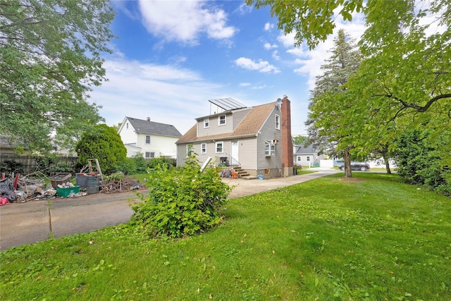 602 Leonard Ave, Uniondale, NY 11553 - back of property with a chimney, a lawn, and entry steps