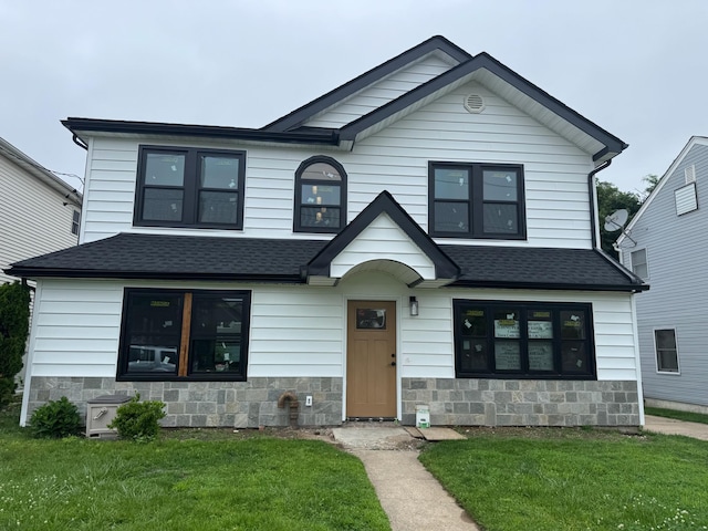 41 Madison Ave, New Hyde Park, NY 11040 - view of front facade with a front yard, a shingled roof, and stone siding