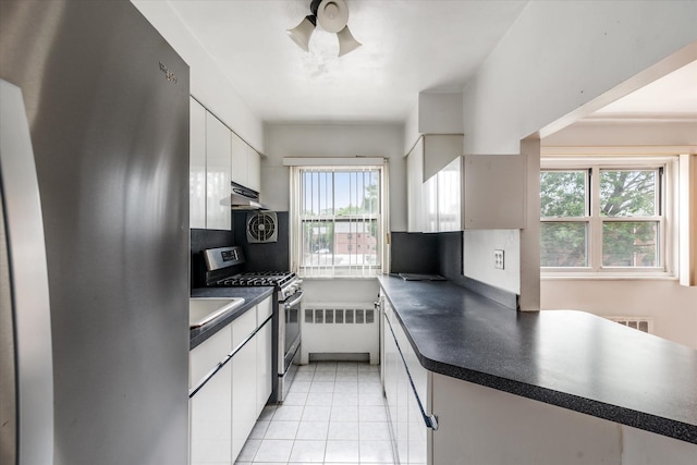 81-29 156th Ave Unit 4, Howard Beach, NY 11414 - kitchen with stainless steel appliances, dark countertops, white cabinets, under cabinet range hood, and a ceiling fan