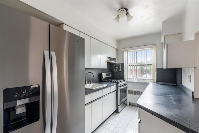 81-29 156th Ave Unit 4, Howard Beach, NY 11414 - kitchen featuring stainless steel appliances, radiator heating unit, dark countertops, under cabinet range hood, and white cabinets