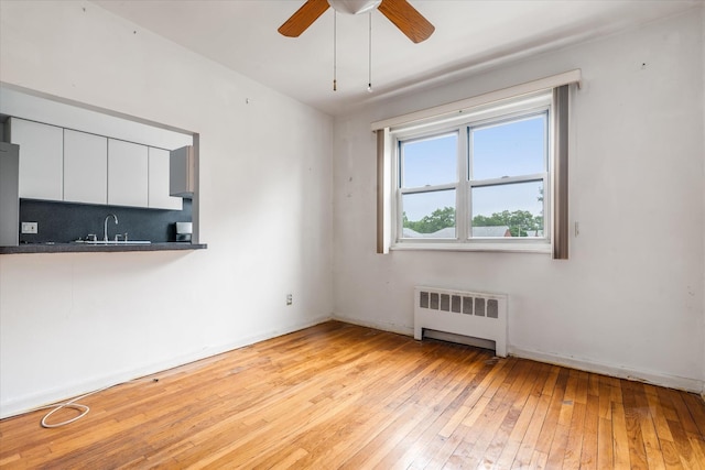 81-29 156th Ave Unit 4, Howard Beach, NY 11414 - empty room with radiator, light wood-style flooring, and a ceiling fan