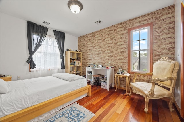 65 Netherwood Dr, Albertson, NY 11507 - bedroom featuring hardwood / wood-style flooring and brick wall