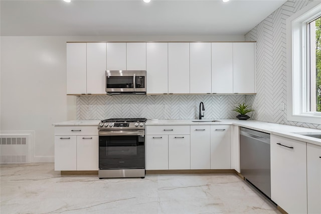 17 Union Rd Unit 208, Spring Valley, NY 10977 - kitchen featuring appliances with stainless steel finishes, decorative backsplash, light marble finish flooring, white cabinetry, and recessed lighting
