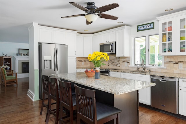4 Tower Rd, Hopewell Junction, NY 12533 - kitchen featuring appliances with stainless steel finishes, a kitchen bar, white cabinetry, a kitchen island, and tasteful backsplash