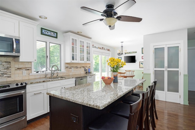 4 Tower Rd, Hopewell Junction, NY 12533 - kitchen with stainless steel appliances, dark wood-style floors, decorative backsplash, white cabinetry, and a breakfast bar