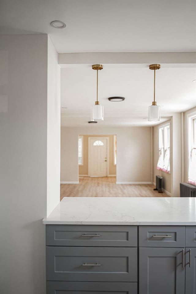 8620 130th St, Richmond Hill, NY 11418 - kitchen featuring gray cabinetry, light stone counters, and decorative light fixtures