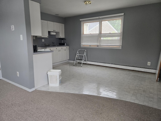 1206 August Rd, North Babylon, NY 11703 - kitchen featuring a baseboard heating unit and white cabinets