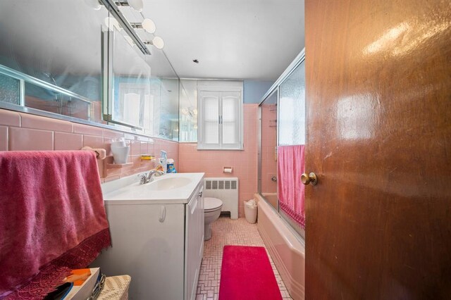 94 Shaw Ave, Valley Stream, NY 11580 - full bathroom featuring radiator, vanity, enclosed tub / shower combo, and tile walls