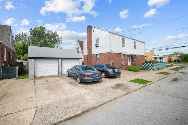 94 Shaw Ave, Valley Stream, NY 11580 - view of front facade featuring an outbuilding, a garage, stucco siding, and a residential view
