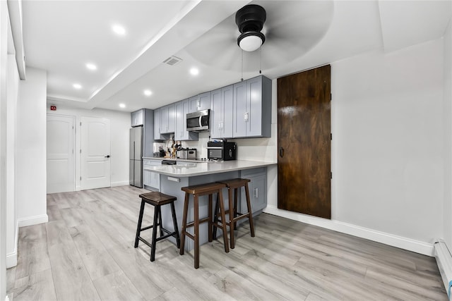 62 Buchanan Pl, Bronx, NY 10453 - kitchen featuring appliances with stainless steel finishes, a ceiling fan, light wood-type flooring, a breakfast bar, and recessed lighting