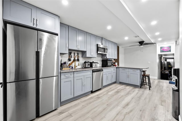 62 Buchanan Pl, Bronx, NY 10453 - kitchen with appliances with stainless steel finishes, gray cabinetry, a peninsula, a ceiling fan, and recessed lighting