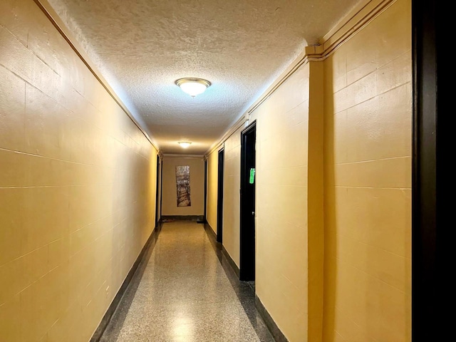 83-83 118th St Unit 6L, Kew Gardens, NY 11415 - hall featuring a textured ceiling, light speckled floor, and concrete block wall
