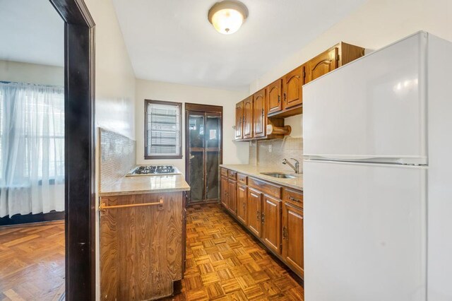 11467 202nd St, Saint Albans, NY 11412 - kitchen featuring freestanding refrigerator, light countertops, brown cabinets, and decorative backsplash