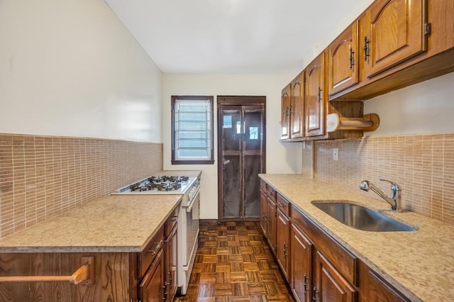 11467 202nd St, Saint Albans, NY 11412 - kitchen with white gas range oven, backsplash, and brown cabinetry