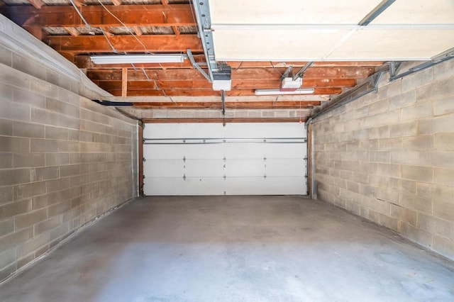 11467 202nd St, Saint Albans, NY 11412 - garage featuring a garage door opener and concrete block wall